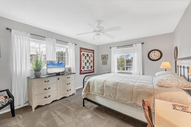 carpeted bedroom featuring a textured ceiling and ceiling fan