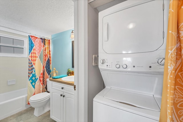 laundry room with a textured ceiling and stacked washer and dryer