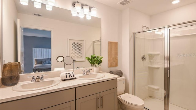 bathroom featuring a shower with door, vanity, and toilet