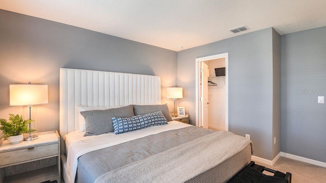 carpeted bedroom with a walk in closet