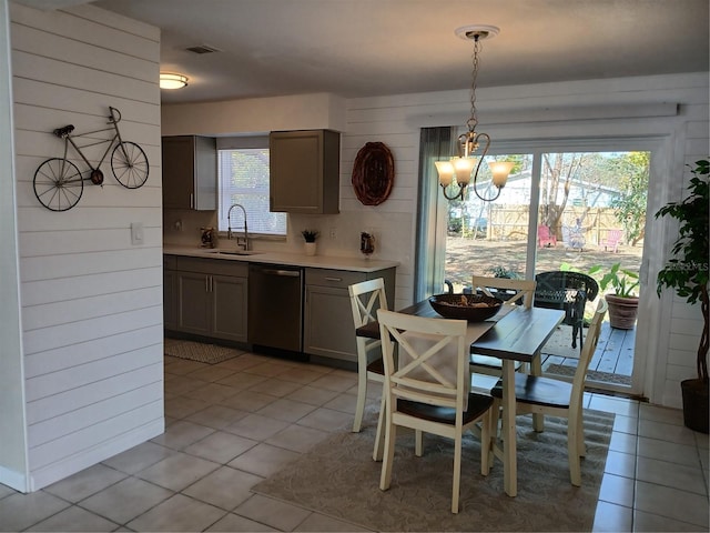 tiled dining area with sink, a notable chandelier, and wooden walls