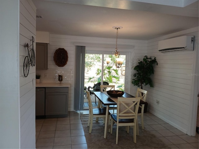 tiled dining room featuring a wall unit AC, an inviting chandelier, and wooden walls