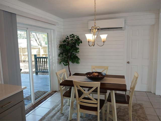 dining space featuring an AC wall unit, a notable chandelier, light tile patterned flooring, and wooden walls