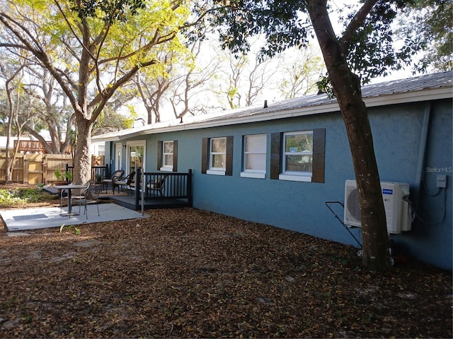 rear view of house with ac unit and a patio