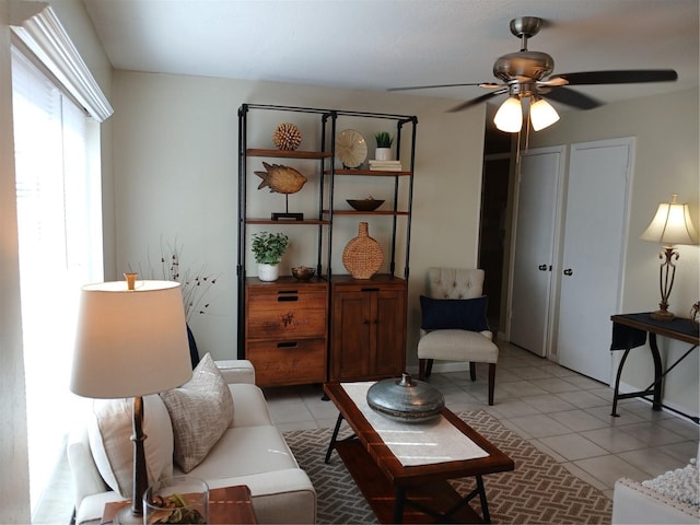 living room with ceiling fan and light tile patterned flooring