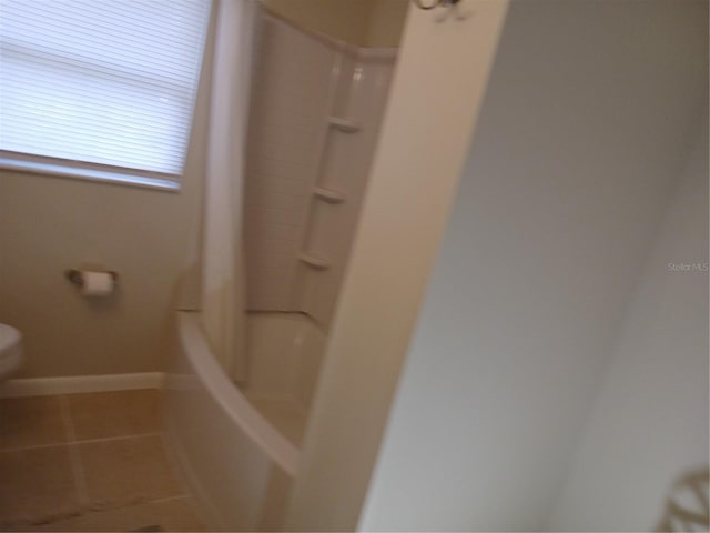 bathroom featuring toilet, tile patterned flooring, and shower / bath combo