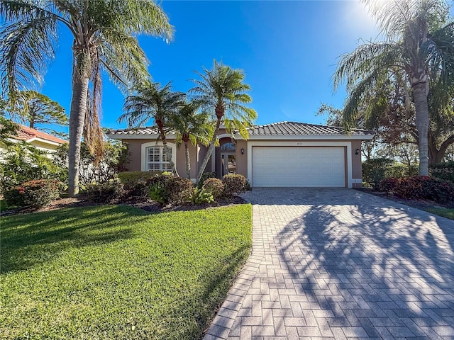 mediterranean / spanish-style home featuring a garage and a front yard