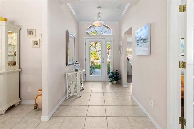 foyer with crown molding and light tile patterned flooring