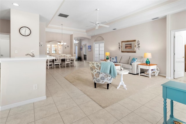 living room featuring light tile patterned floors, a raised ceiling, and a healthy amount of sunlight