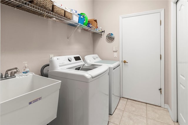 washroom featuring sink, light tile patterned floors, and separate washer and dryer