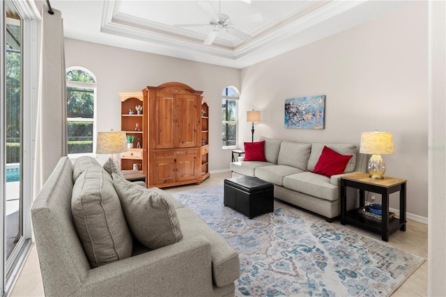 living room with crown molding, a healthy amount of sunlight, ceiling fan, and a tray ceiling