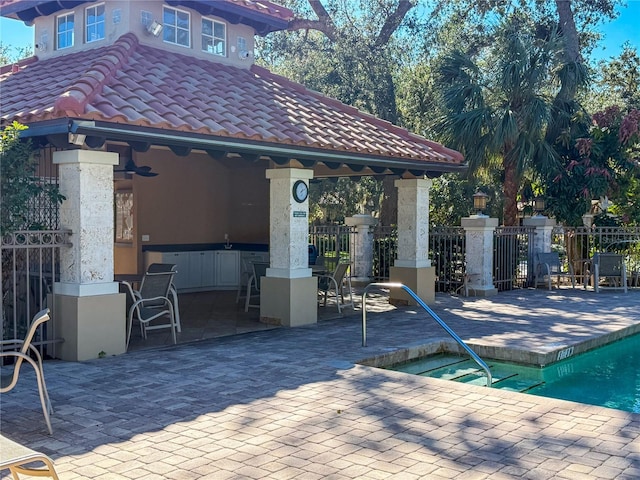 view of patio / terrace featuring a gazebo, a community pool, an outdoor bar, and ceiling fan