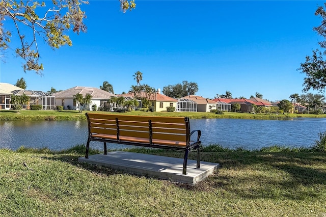 view of dock with a lawn and a water view