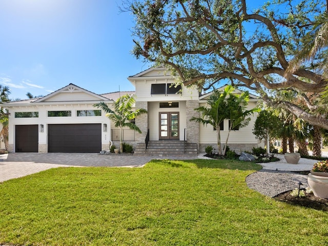 view of front facade with a front lawn, a garage, and french doors