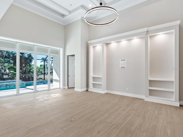 unfurnished living room featuring light wood-type flooring and a towering ceiling