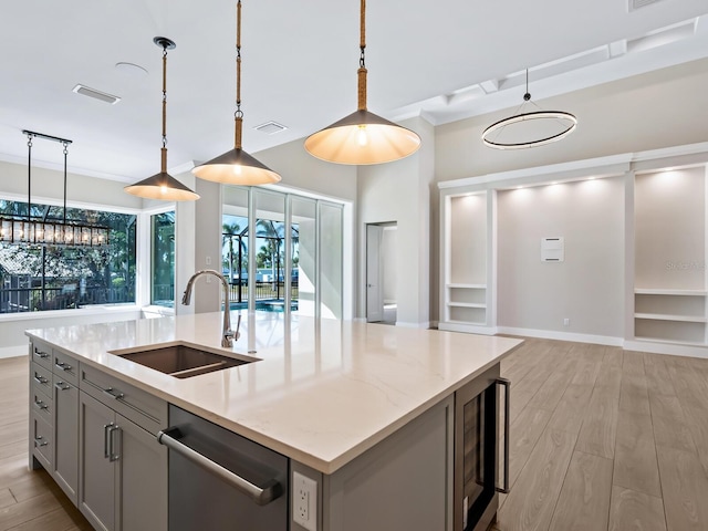 kitchen with sink, dishwasher, decorative light fixtures, gray cabinets, and a kitchen island with sink