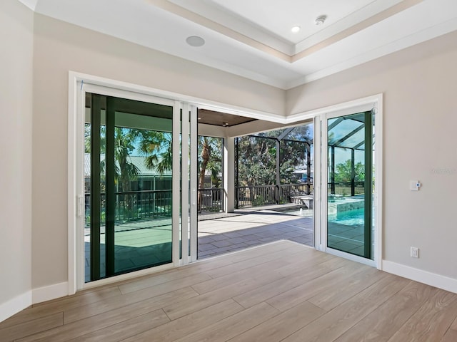 doorway to outside featuring light wood-type flooring, plenty of natural light, and crown molding