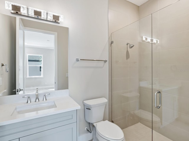 bathroom featuring vanity, toilet, and an enclosed shower