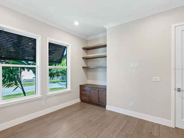 spare room featuring crown molding and light hardwood / wood-style flooring