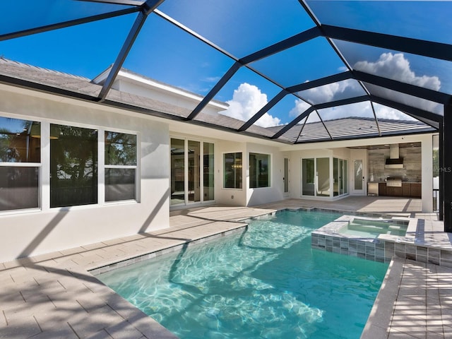 back of house featuring glass enclosure, a patio area, and a pool with hot tub