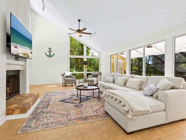 1214 Sea Plume Way, Sarasota, FL 34242 - living area with a ceiling fan, a lit fireplace, high vaulted ceiling, and light tile patterned floors