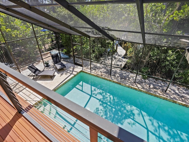 outdoor pool with glass enclosure and a patio