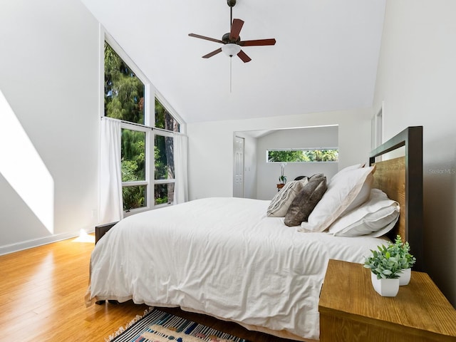 bedroom featuring baseboards, high vaulted ceiling, ceiling fan, and wood finished floors