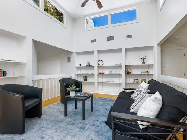 living room with hardwood / wood-style floors, ceiling fan, wood ceiling, and a high ceiling