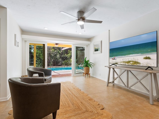 living area featuring tile patterned flooring, recessed lighting, a beach view, a ceiling fan, and baseboards