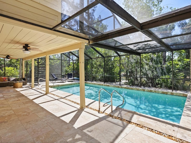 view of pool with glass enclosure, ceiling fan, and a patio area