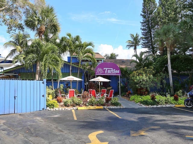 view of property with uncovered parking and fence