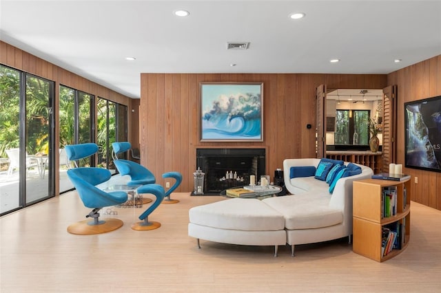 living room featuring light wood-type flooring and wooden walls