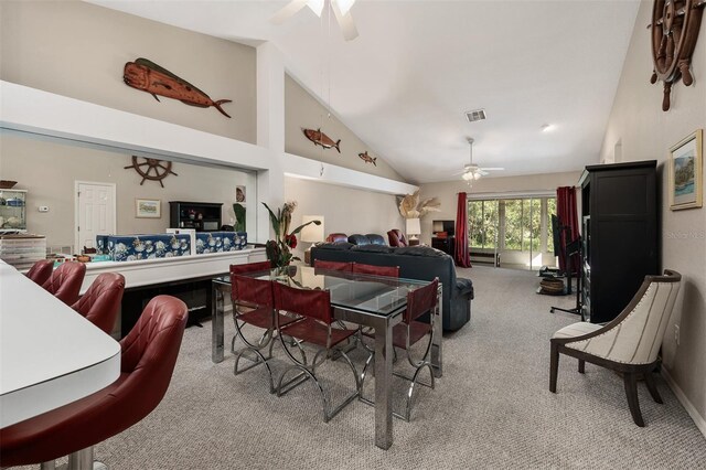 carpeted dining room featuring high vaulted ceiling and ceiling fan