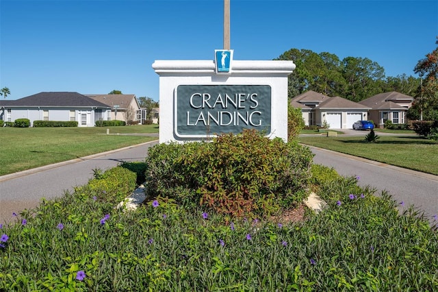 community / neighborhood sign with a yard