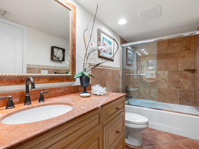 full bathroom with vanity, shower / bath combination with glass door, tile patterned floors, and toilet