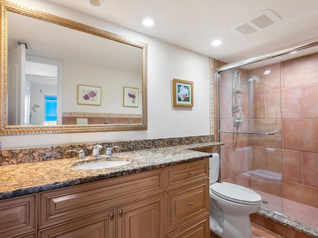 bathroom with vanity, toilet, and an enclosed shower