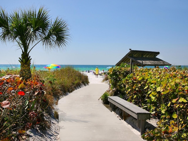 surrounding community with a water view and a view of the beach