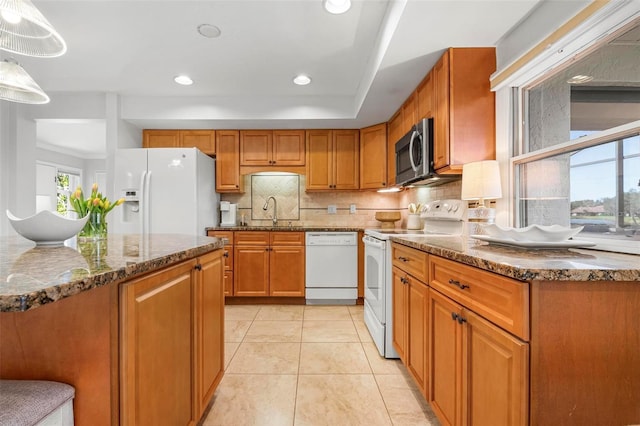 kitchen with white appliances, sink, hanging light fixtures, decorative backsplash, and light tile patterned floors