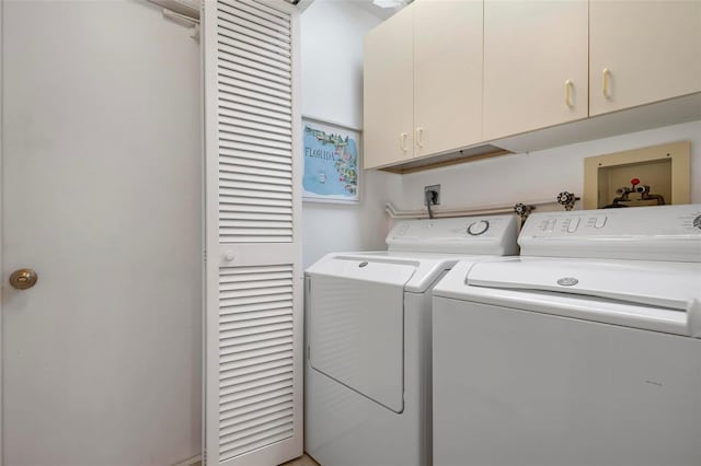 washroom with washer and dryer and cabinets