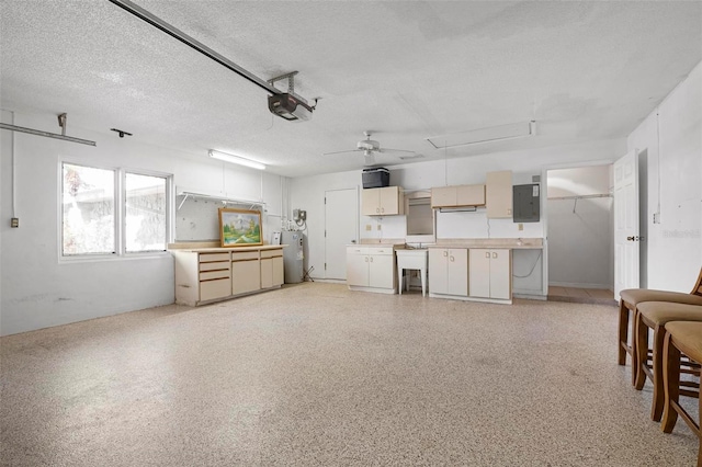 interior space featuring electric water heater, electric panel, a garage door opener, sink, and ceiling fan