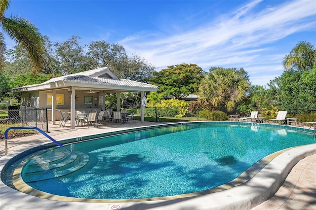 view of swimming pool featuring ceiling fan and a patio area