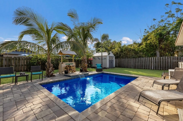 view of swimming pool featuring a storage unit, a patio area, and a yard