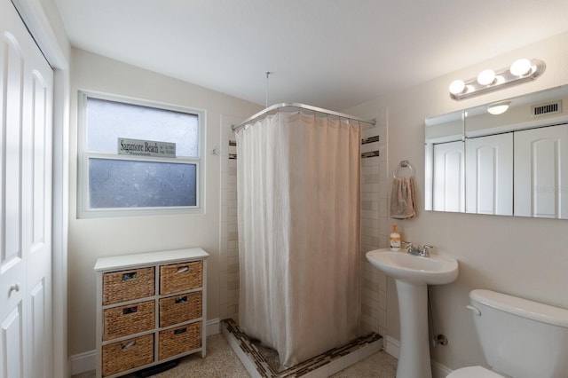 bathroom featuring a shower with curtain, toilet, and sink