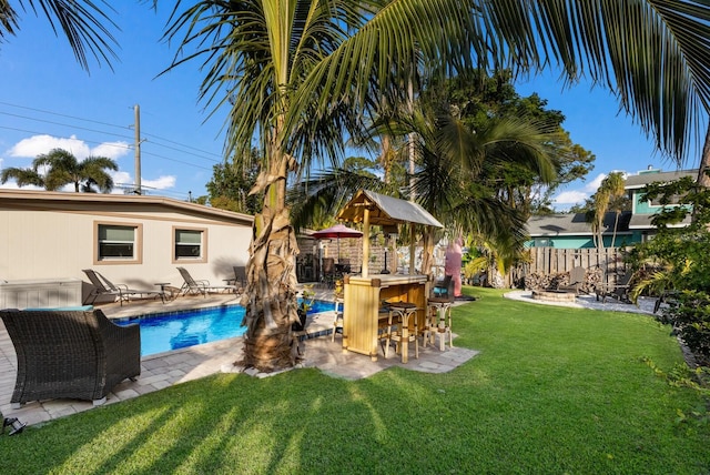 view of pool with a yard and an outdoor bar