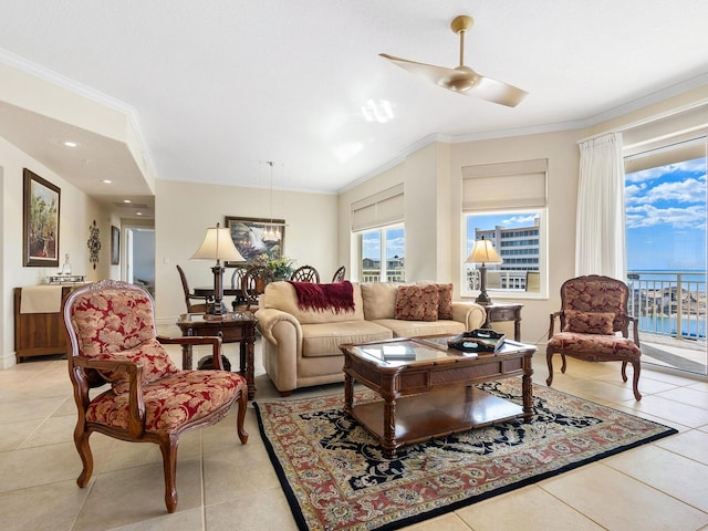 living room featuring ceiling fan, a water view, light tile patterned floors, and crown molding