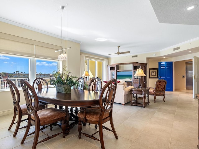 tiled dining space with a textured ceiling, ceiling fan with notable chandelier, and crown molding