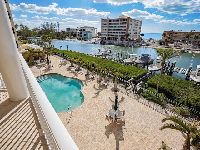 view of pool featuring a boat dock, a water view, and a patio area