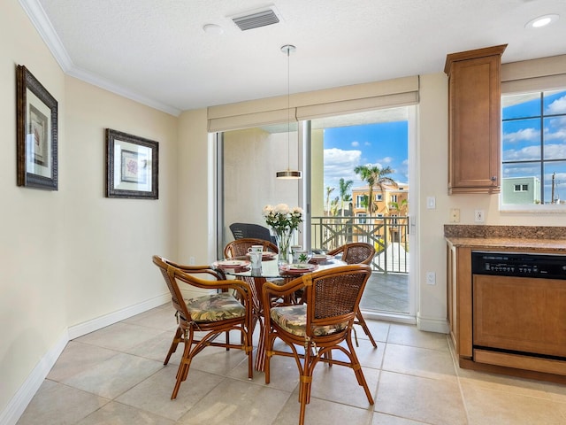 dining room with a healthy amount of sunlight, ornamental molding, a textured ceiling, and light tile patterned floors