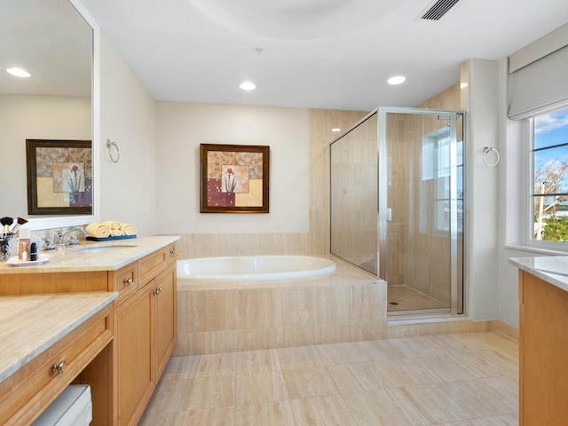 bathroom featuring plus walk in shower, vanity, and tile patterned floors