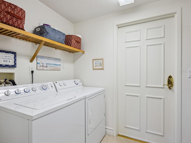 washroom with independent washer and dryer and a textured ceiling